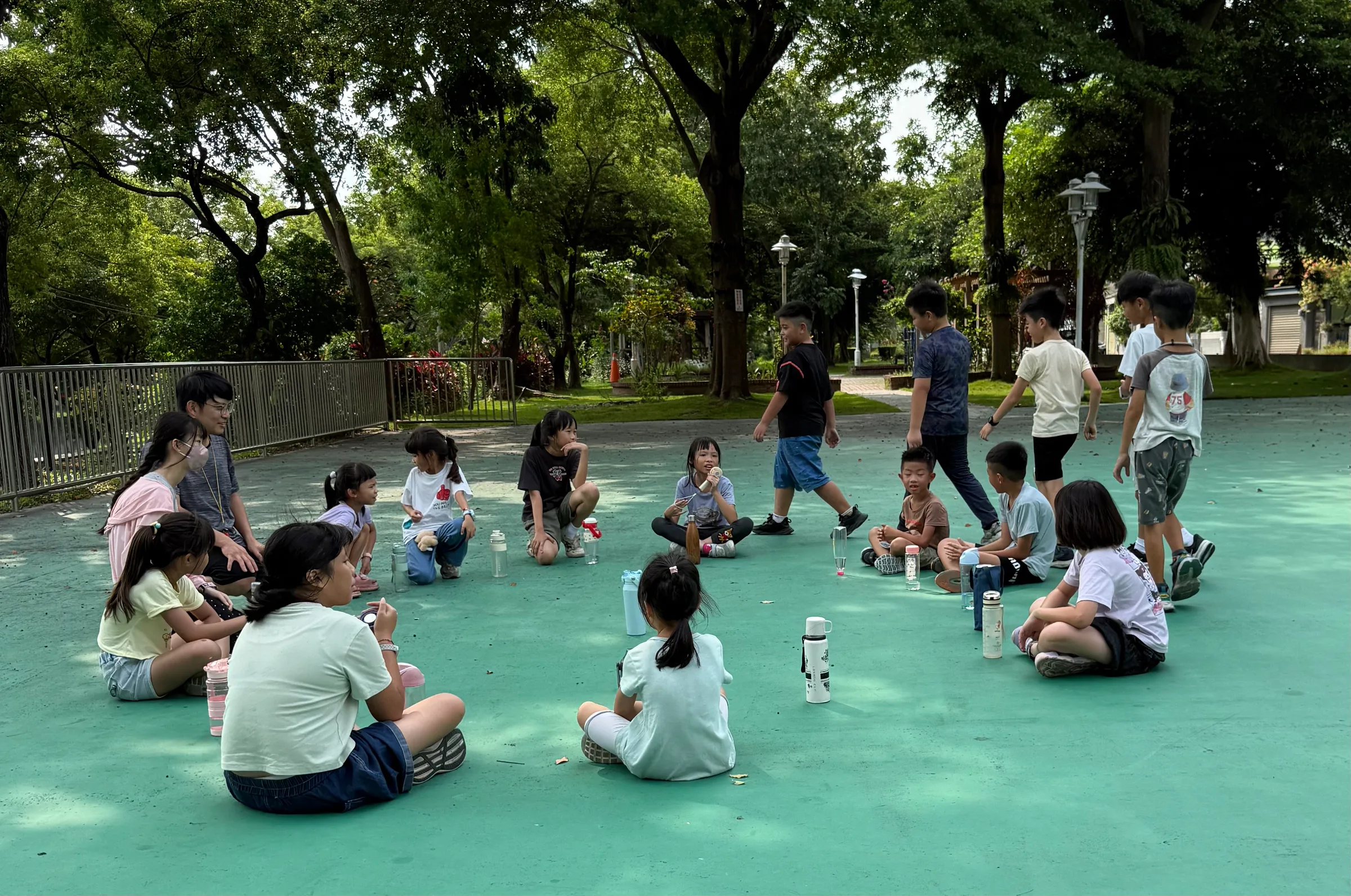 公園綠色地面上,孩子們圍坐成一圈