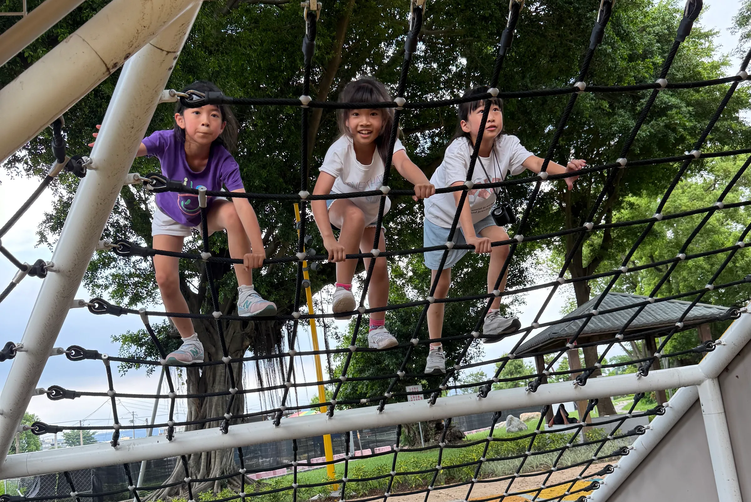 三個女孩在公園爬繩網
